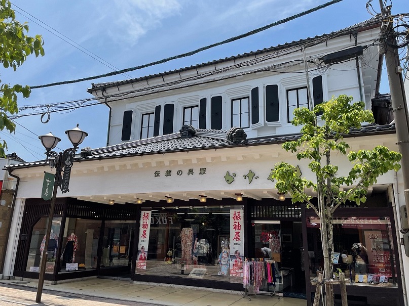 白色の漆喰壁で施された2階建ての1階がかげやま呉服店の店舗となっている建物外観の写真