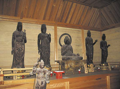 中央に座禅を組み座っている仏像、その両側にそれぞれ立っている2体の仏像、一段下がった場所に立っている1体の仏像の写真