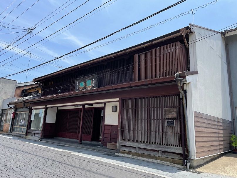 漆喰壁に窓に平格子を施した木造2階建ての「國暉酒造」の建物外観の写真