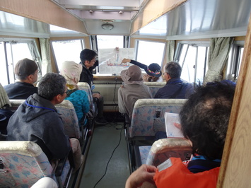 矢田渡船に乗ってガイドの説明を聞いている参加者の写真