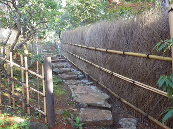 新しく垣根が設置され、飛び石の道がきれいに整備された施工後の御風呂屋周辺の写真