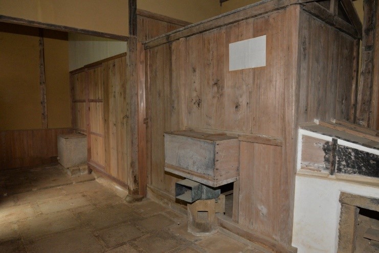 木の板が張られた壁と四角い石を並べて作られた床になっている御風呂屋の土間の写真