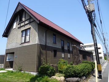 縦長窓と急勾配の切妻屋根などを用いた2階建ての福田平治・与志記念館の建物外観の写真