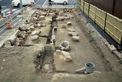 中央に溝が掘られ、大小複数の石が置かれている、大手前通りで発見された石組水路の写真