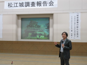 報告会にて講演を行う麓和善名古屋工業大学大学院教授の写真