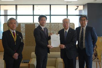 松浦会長、西村副会長から上定市長に答申書を渡す様子