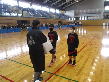 松江市総合体育館メインアリーナで行われた、第45回松江市スポ―ツ少年団親子運動会の閉会式。優勝した島根町スポーツ少年団の代表二人が優勝賞品授与の写真