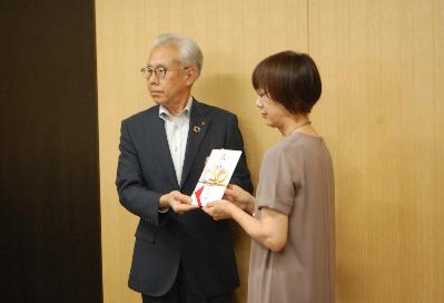 講武副市長が錦織恵理さん（錦織圭選手の母）に激励金を贈呈している様子。