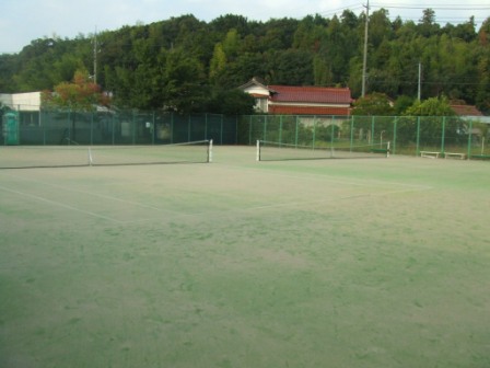 緑に囲まれた美保関総合運動公園テニスコートC・Dコートの写真。木々の隙間からところどころに家が見える。