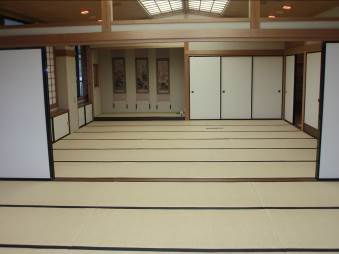 天窓から光がさしこんでいる畳がしかれたサンライフ松江の和室の写真、奥に3幅の掛け軸が見えている
