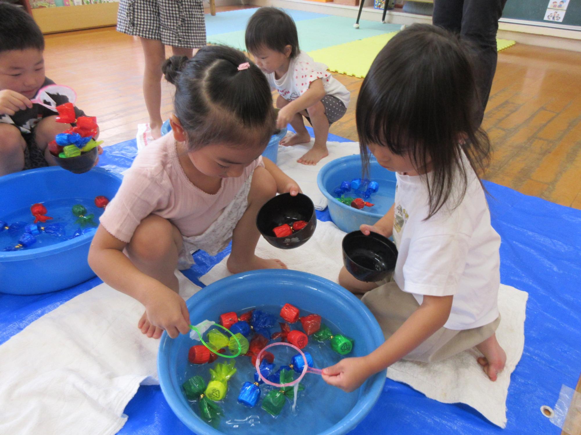 金魚すくいをするこどもたち