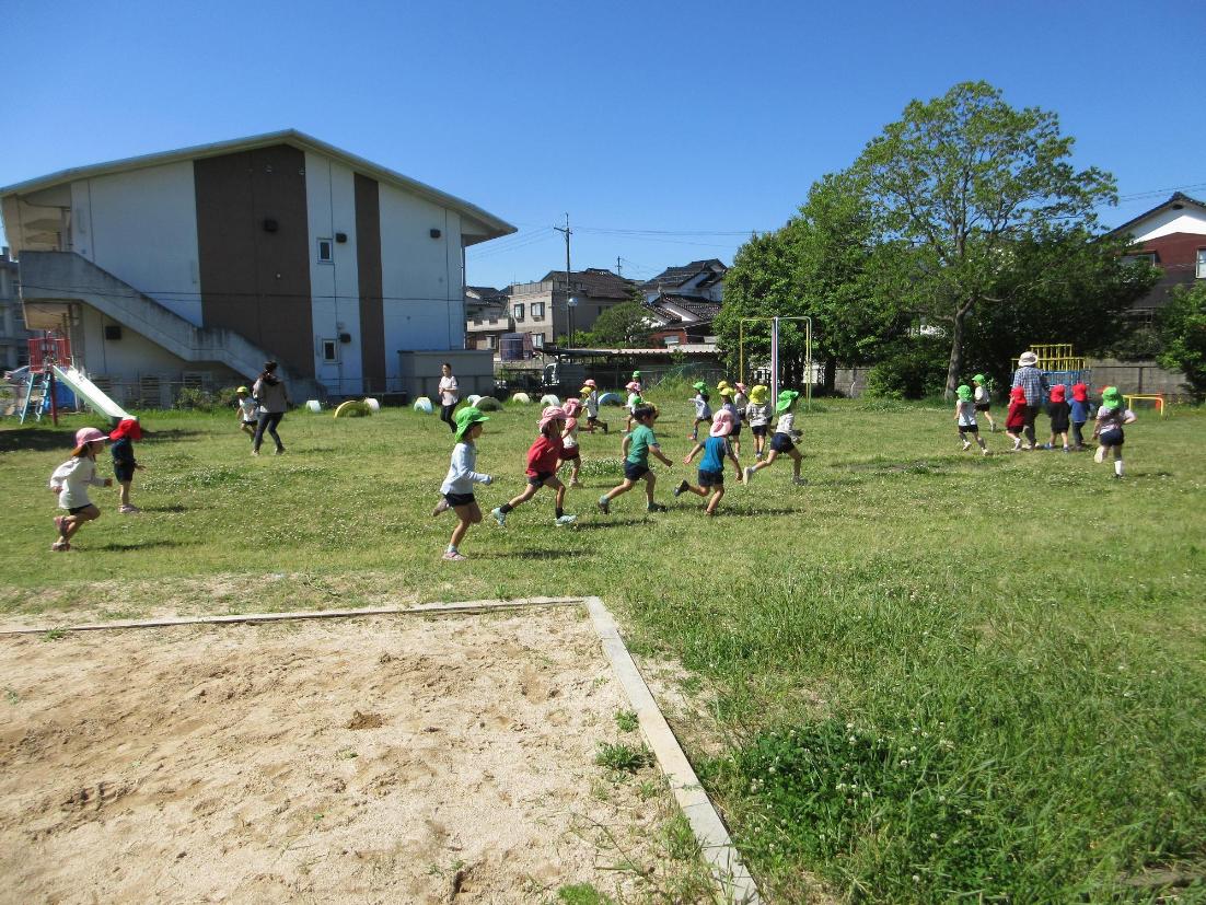 園庭で遊ぶこどもたちの写真