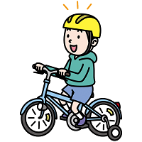補助輪つき自転車に乗る子供