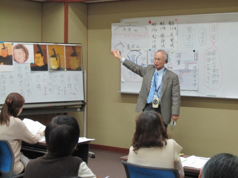 松江城と城下町について説明する男性の先生と、ホワイトボードに注目している受講者達の写真