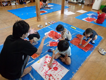 子どもたちが絵の具を手に付けて遊んでいる写真
