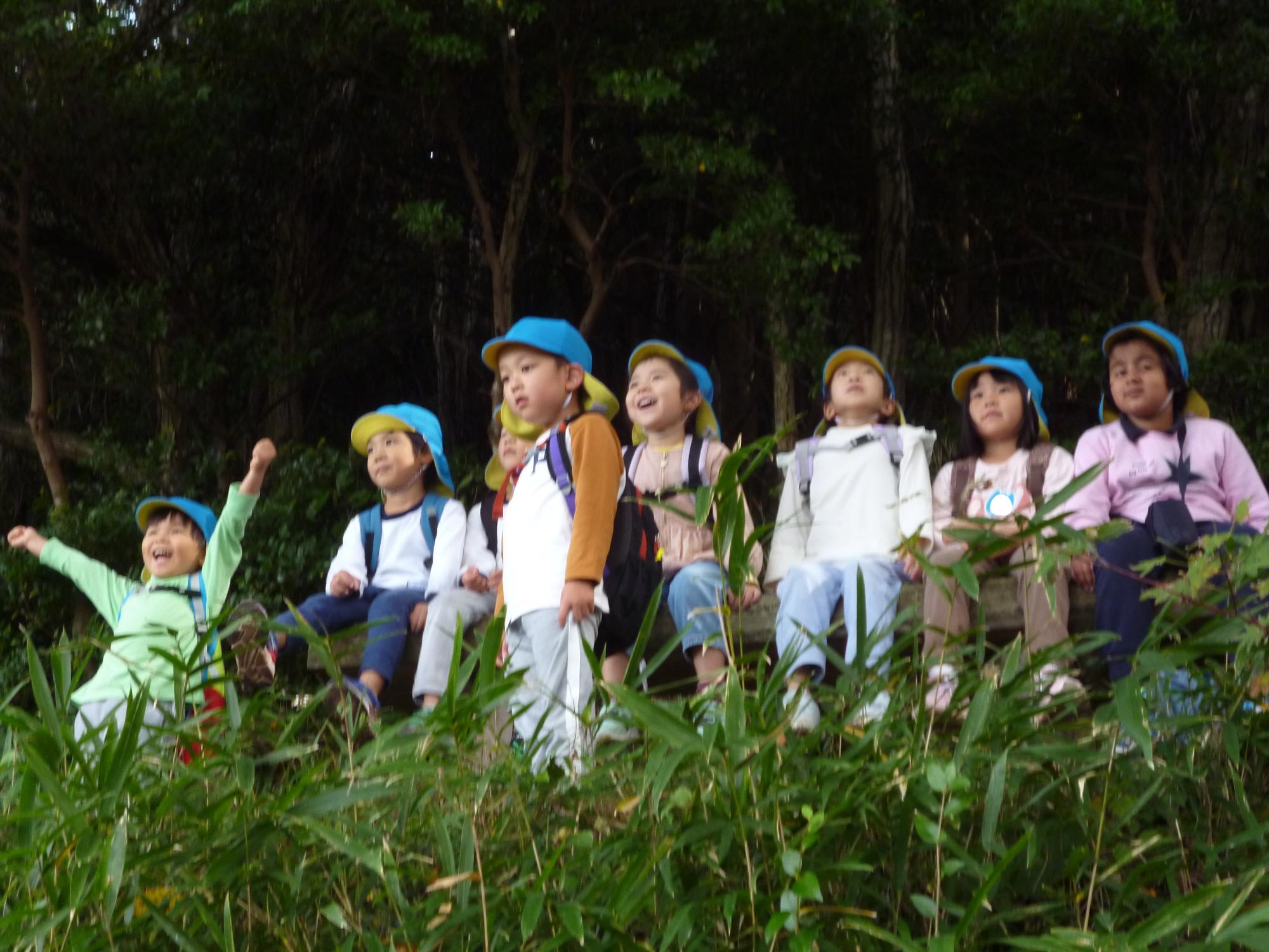 山道のベンチに座って景色を眺めているこどもたち