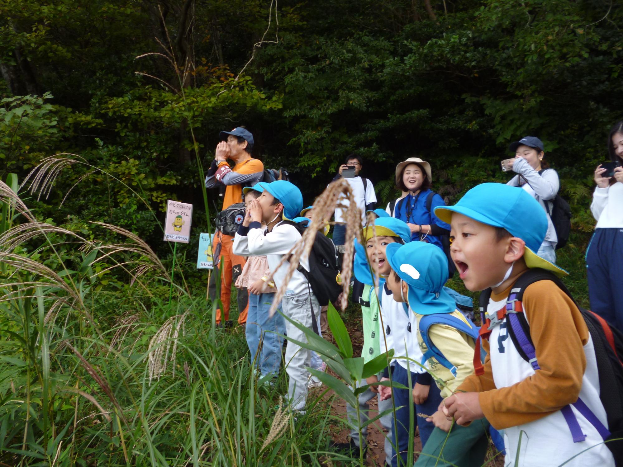 山道から「やっほー」と大きな口をあけているこどもたち