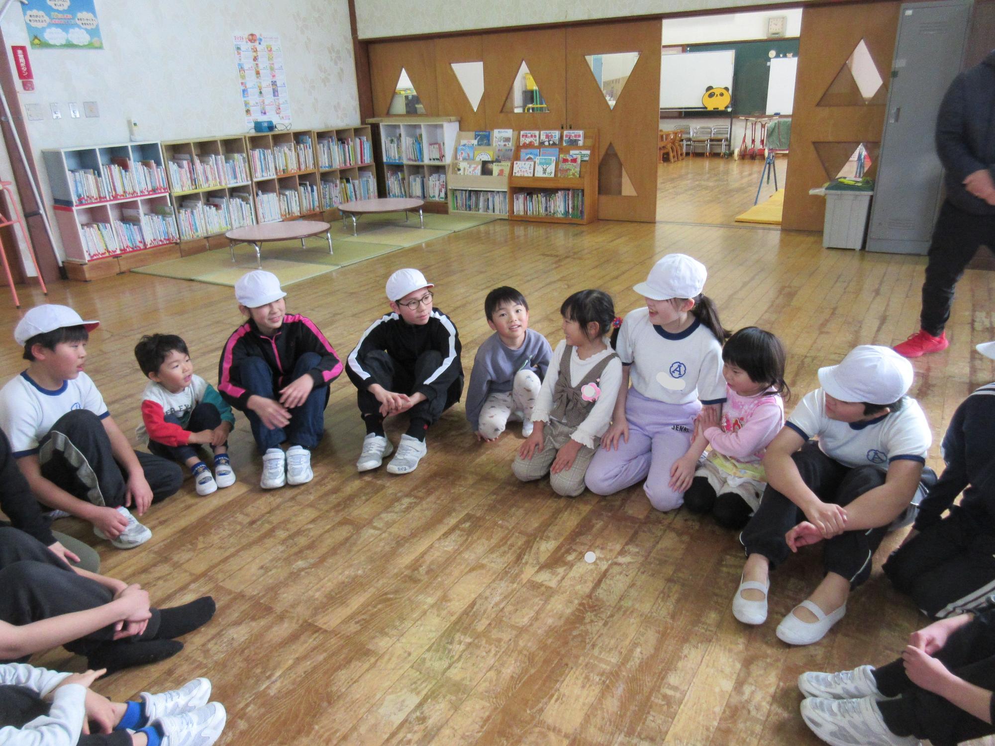 幼稚園と小学校5年生のこども達が輪になって座り、感想を話したり、聞いたりしている