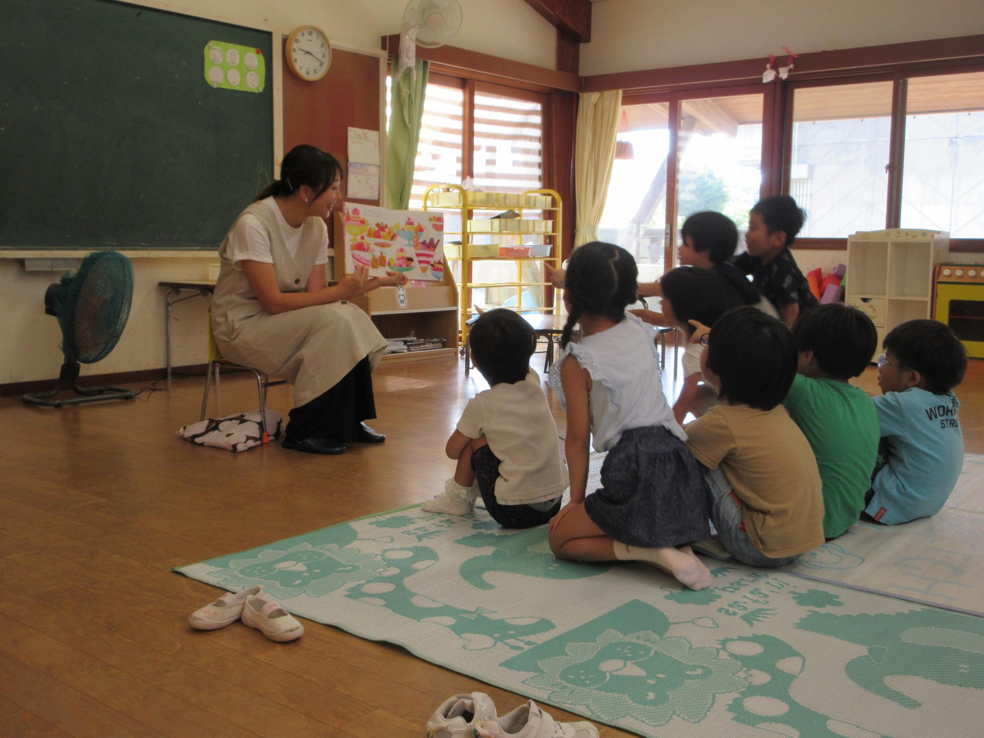 保護者の方による絵本の読み聞かせ。夢中になって見入っているこども達です。