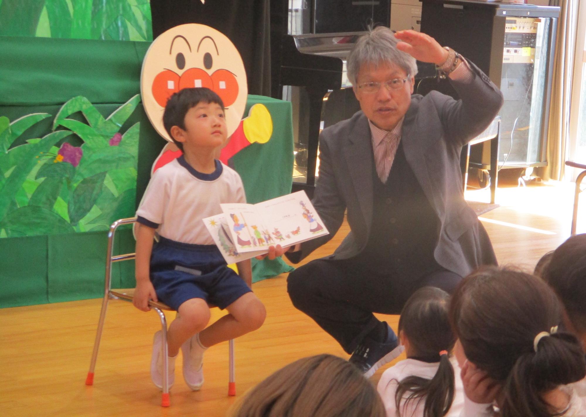 誕生会。園長先生から絵本のプレゼントをもらいます。