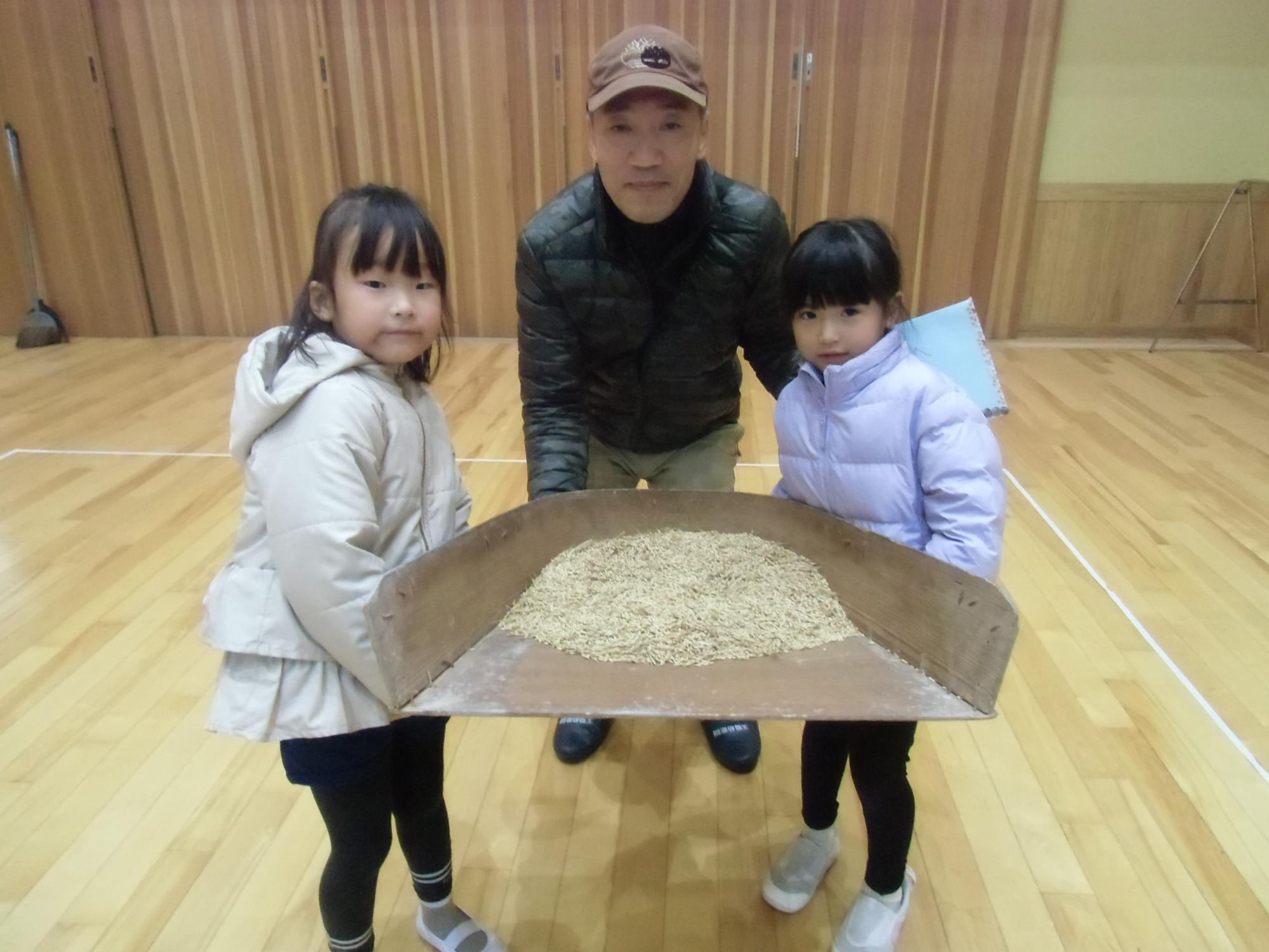 脱穀したコメを持つ様子