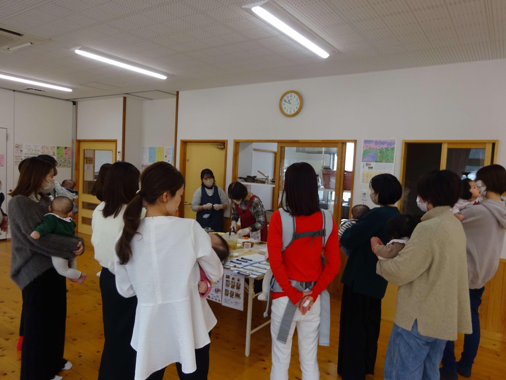 離乳食教室で管理栄養士から講義を受ける母親の写真