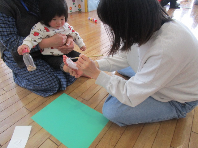 足形アートを楽しむ親子の写真