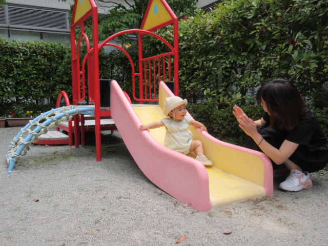 あいあいの中庭ですべり台をしている親子の写真