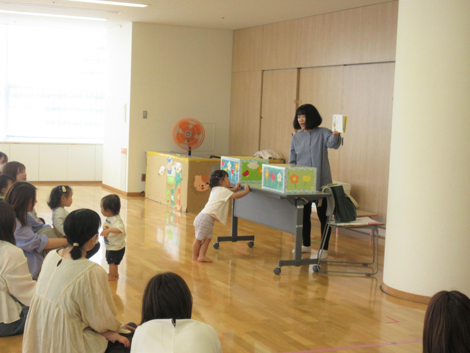 絵本の読み聞かせや手遊びなど、親子で楽しんでいる様子。