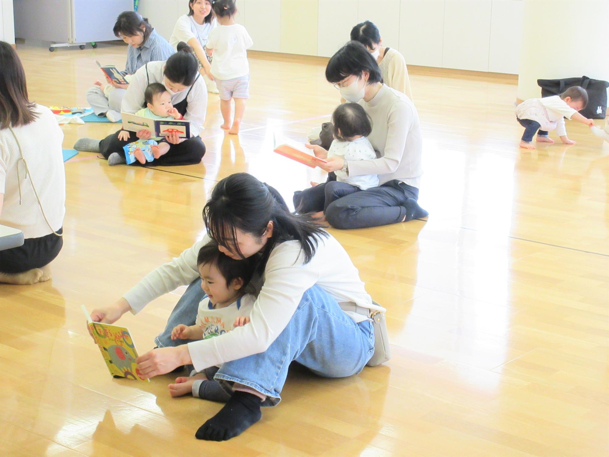親子でいろいろな絵本を手に取り、読んでいる様子