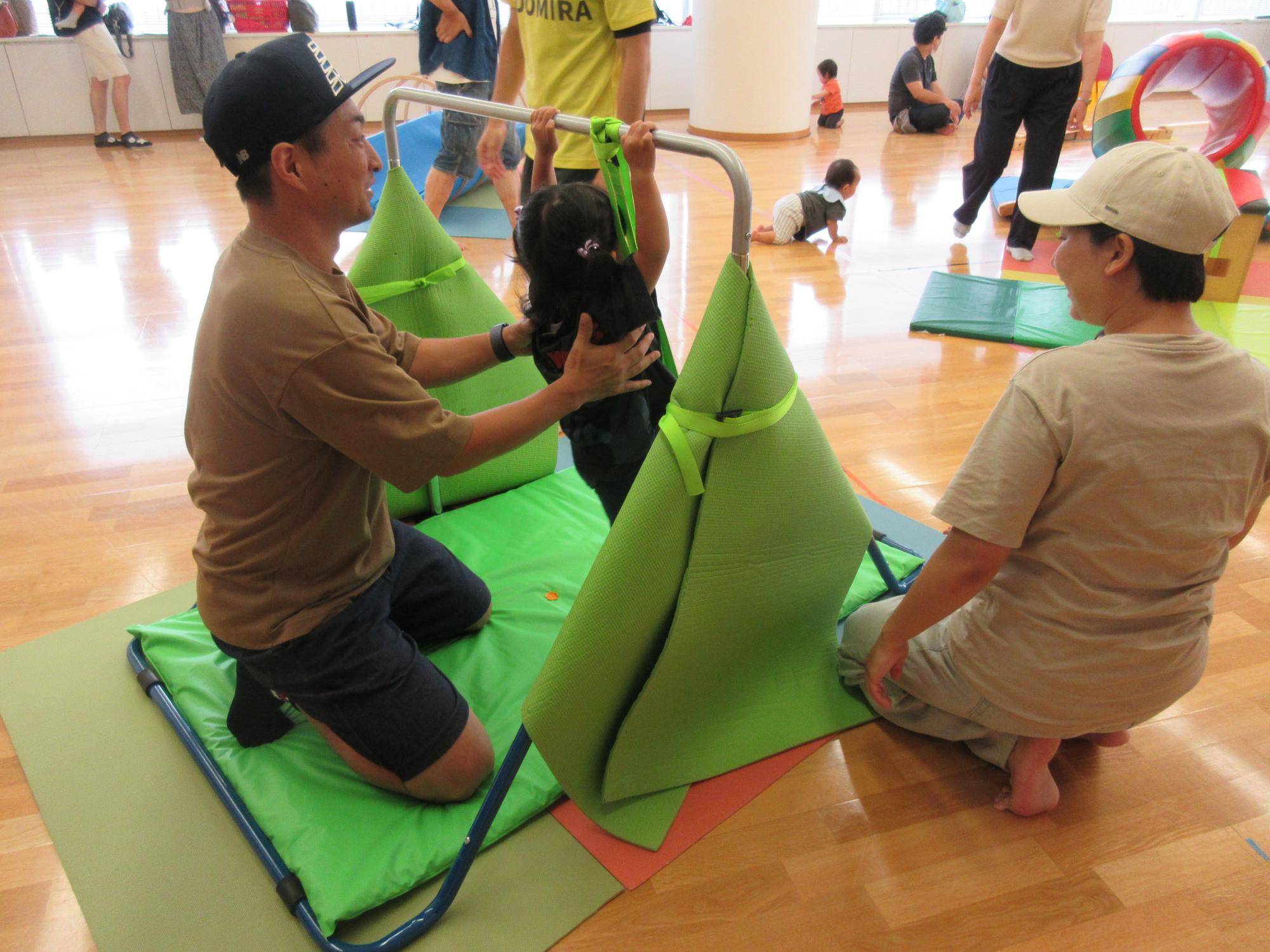 鉄棒で遊ぶ親子