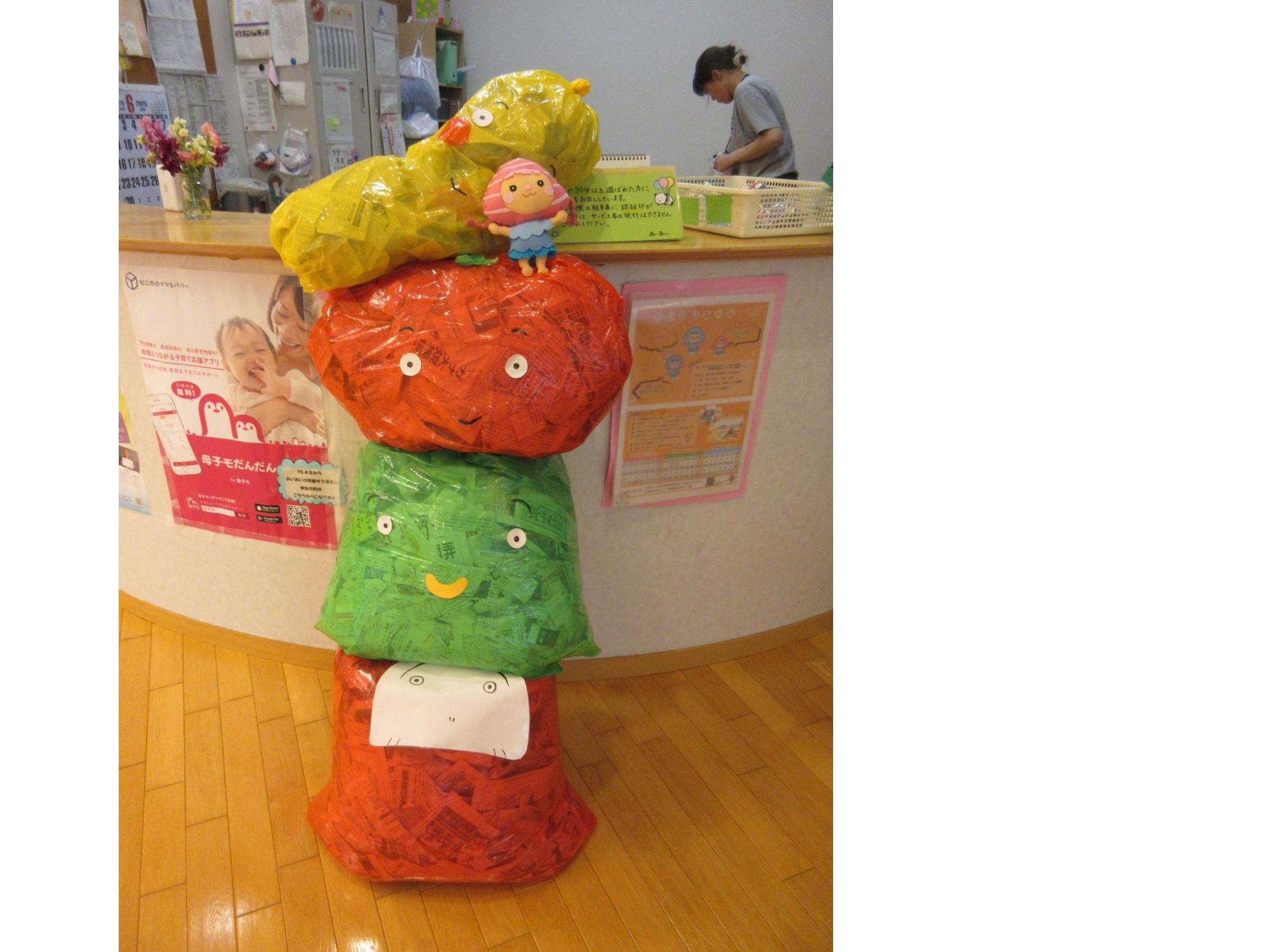 新聞紙で作っだるまさんと果物たち