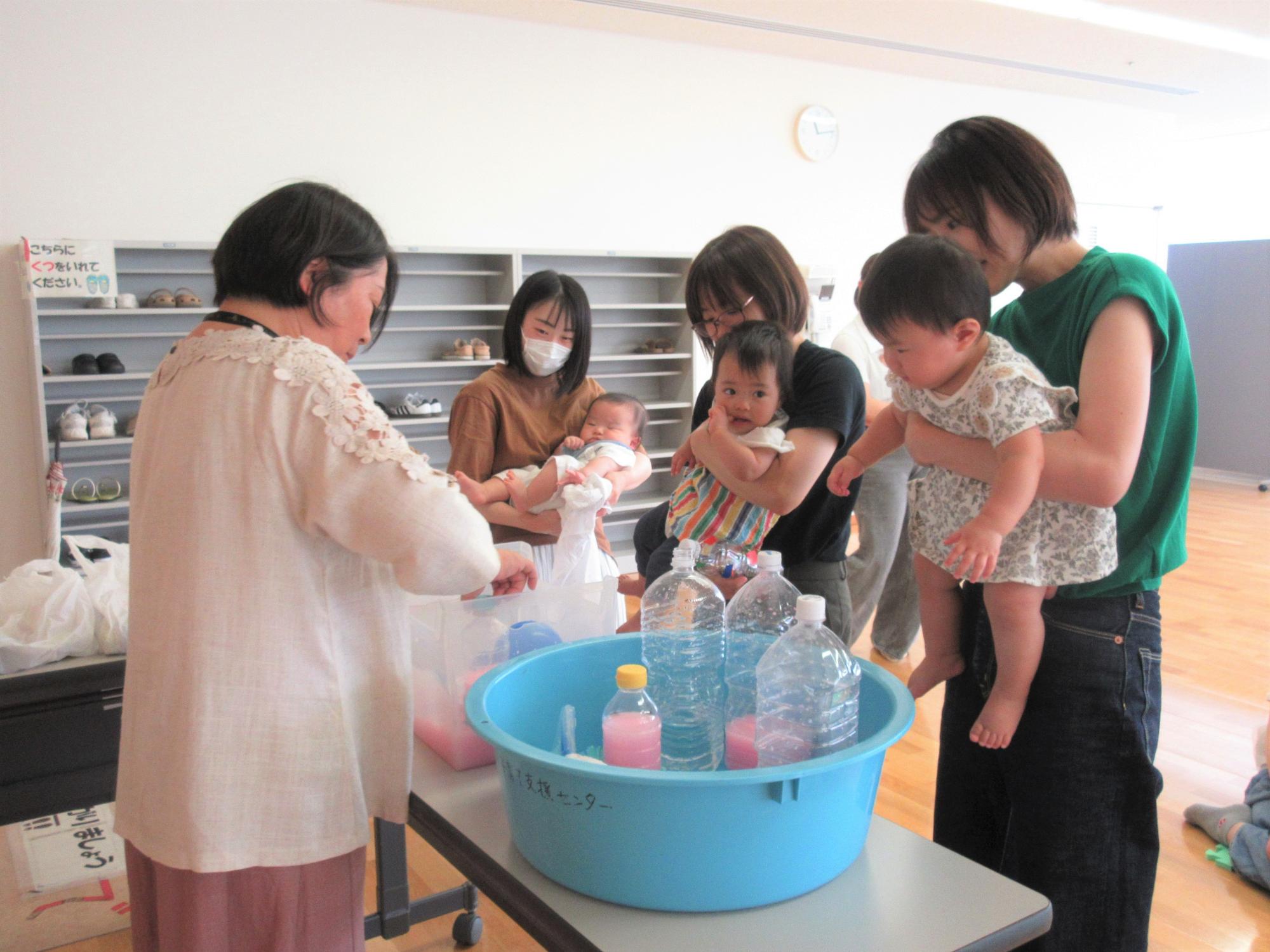 水を入れた、たらいで遊び方を見せている。