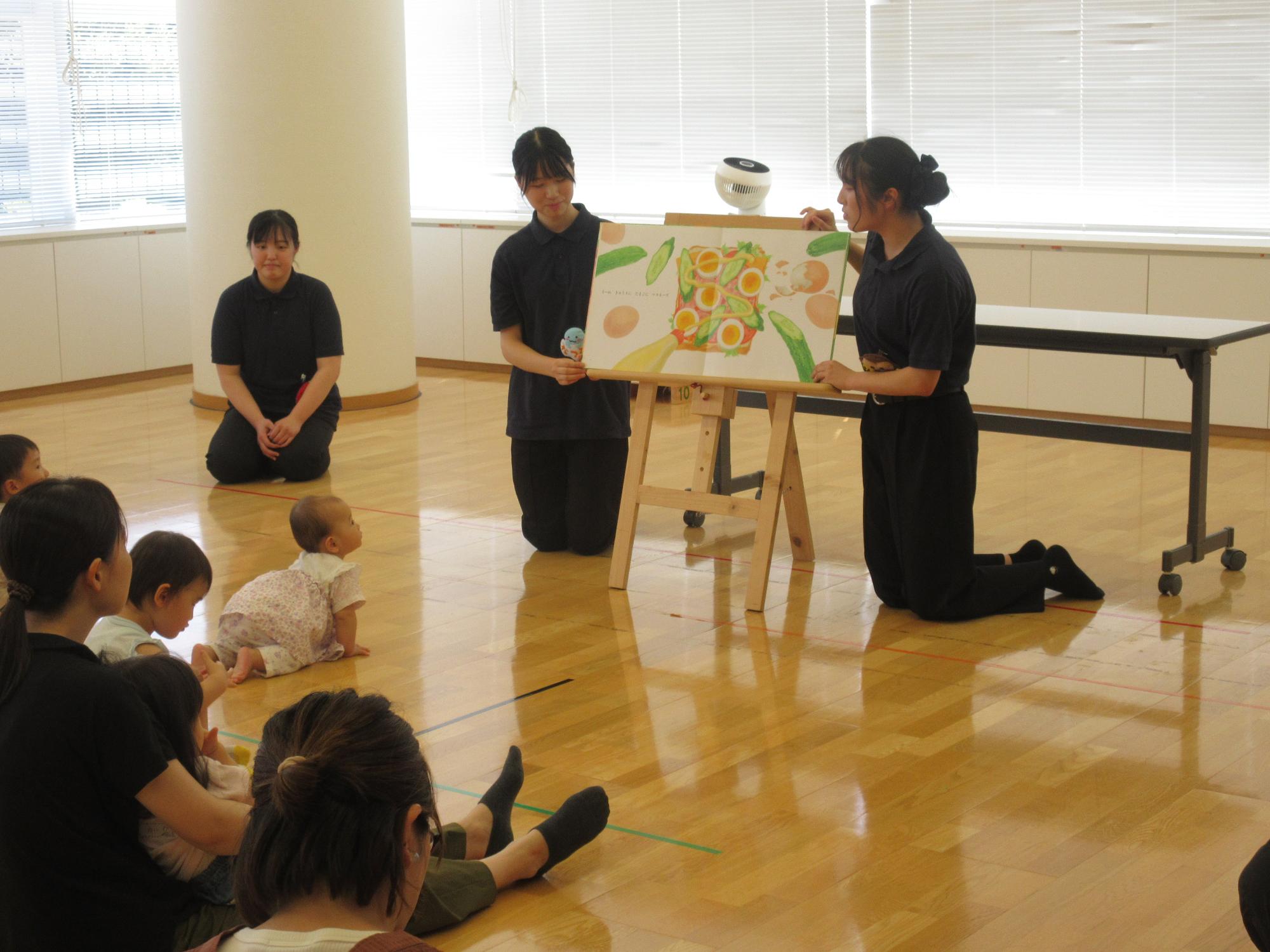 学生が絵本の読み聞かせをする様子