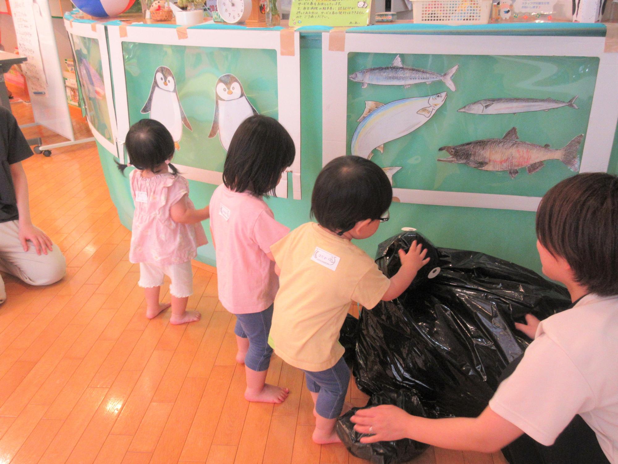 つどい終了後に、衝立の魚やペンギンの絵を指差しながら見ている様子