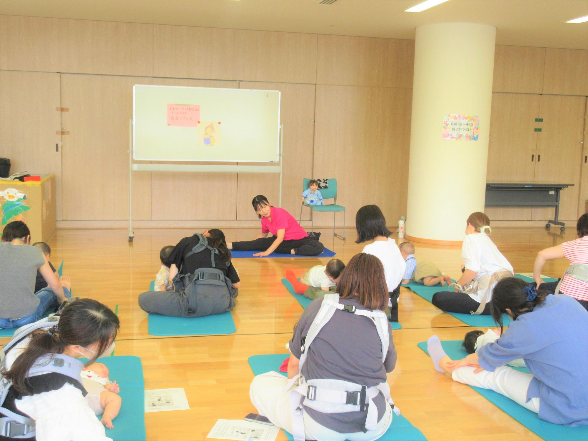 親子でダンスをする前に、お母さんの身体をほぐし、ストレッチしている様子