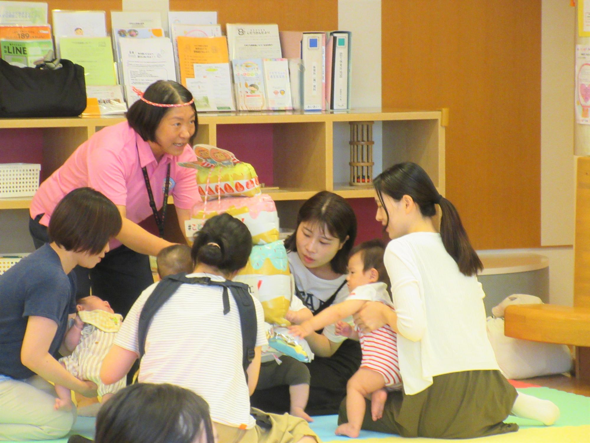 親子で風船で作ったお神輿で夏祭りを感じながらつどいを楽しんでいる様子