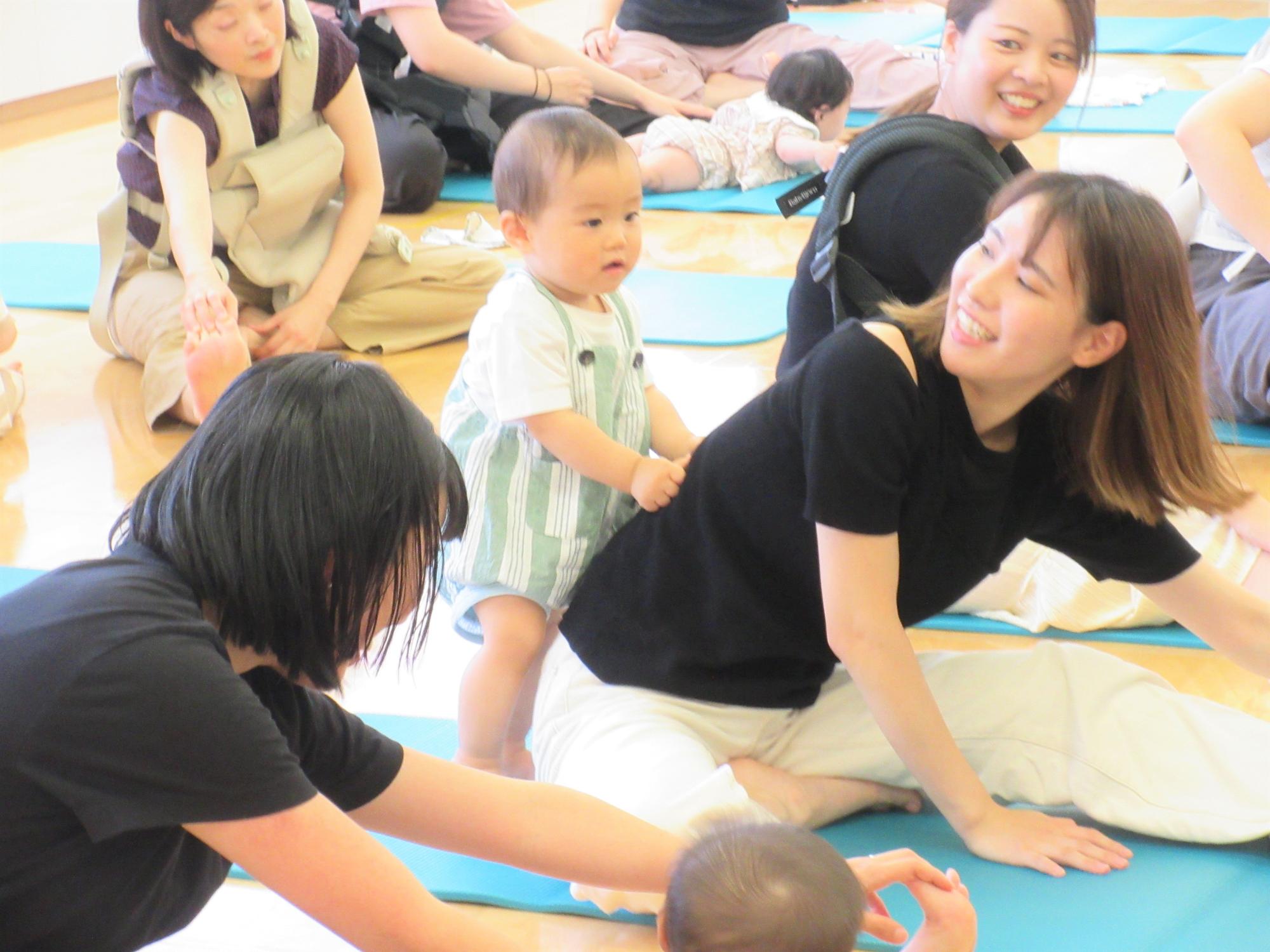 お母さんがストレッチしている背中を押してあげるお子さんのかわいい姿