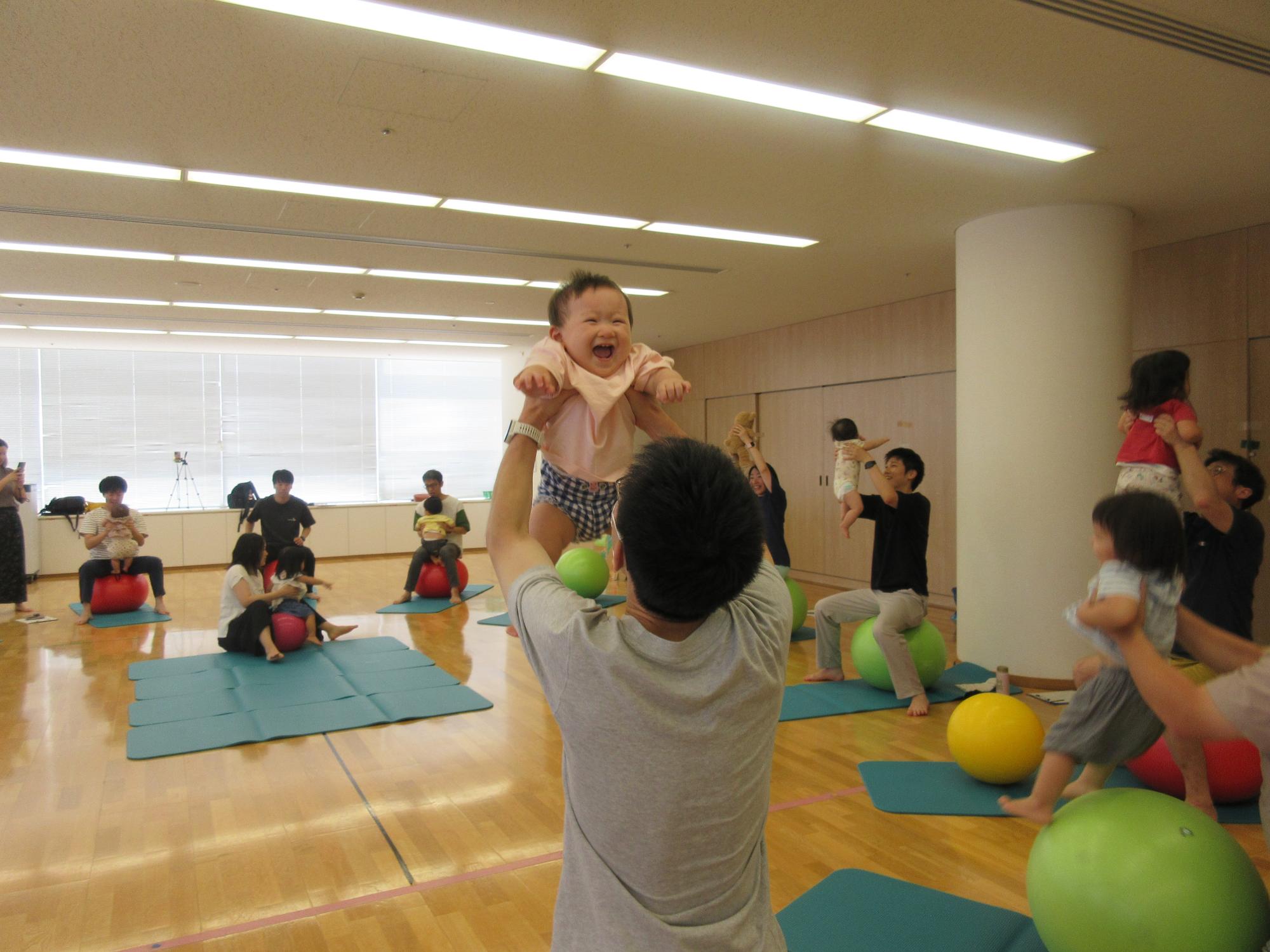 たかいたかいをしてもらい笑顔の赤ちゃん