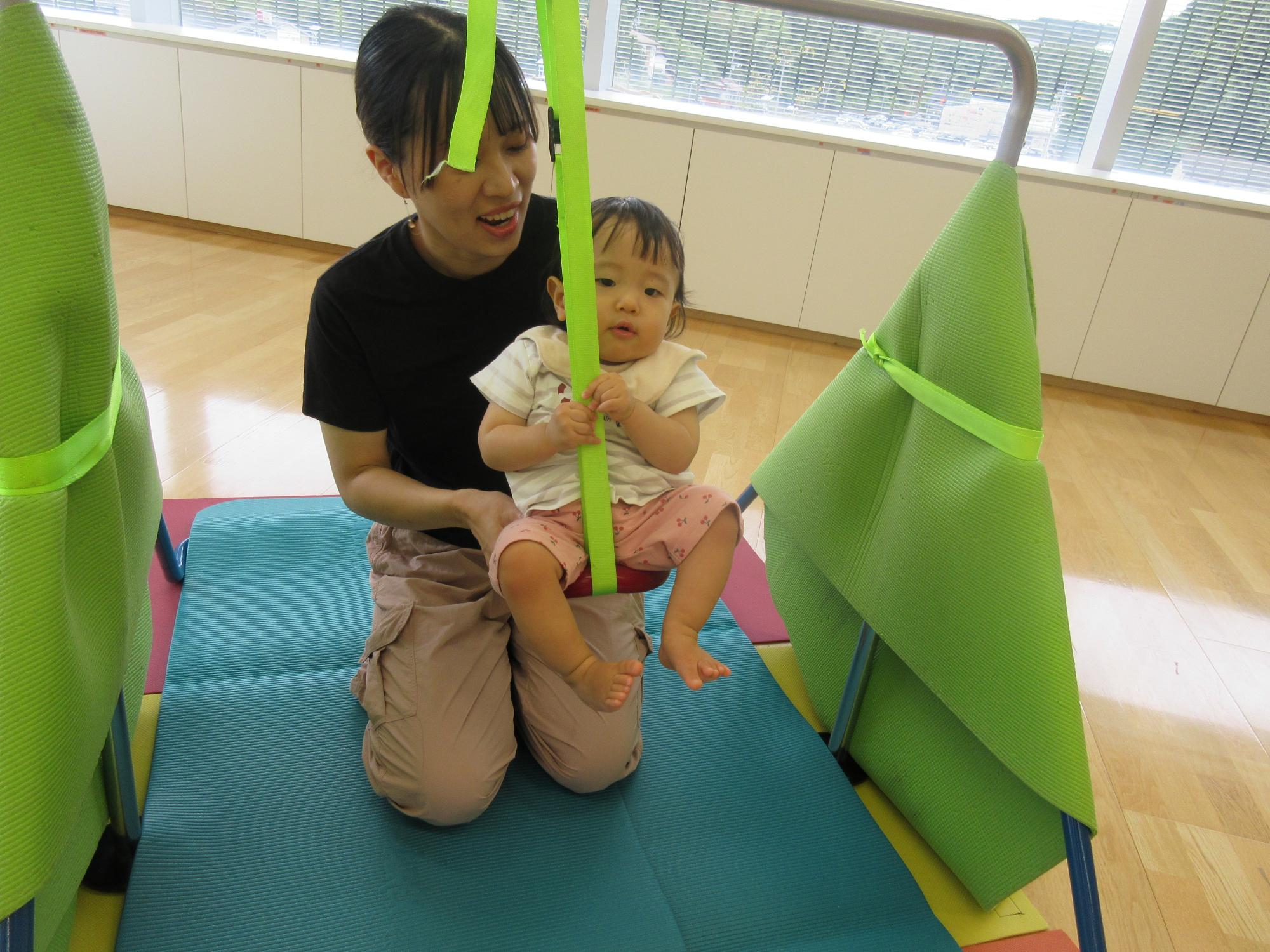 鉄棒で遊ぶ親子