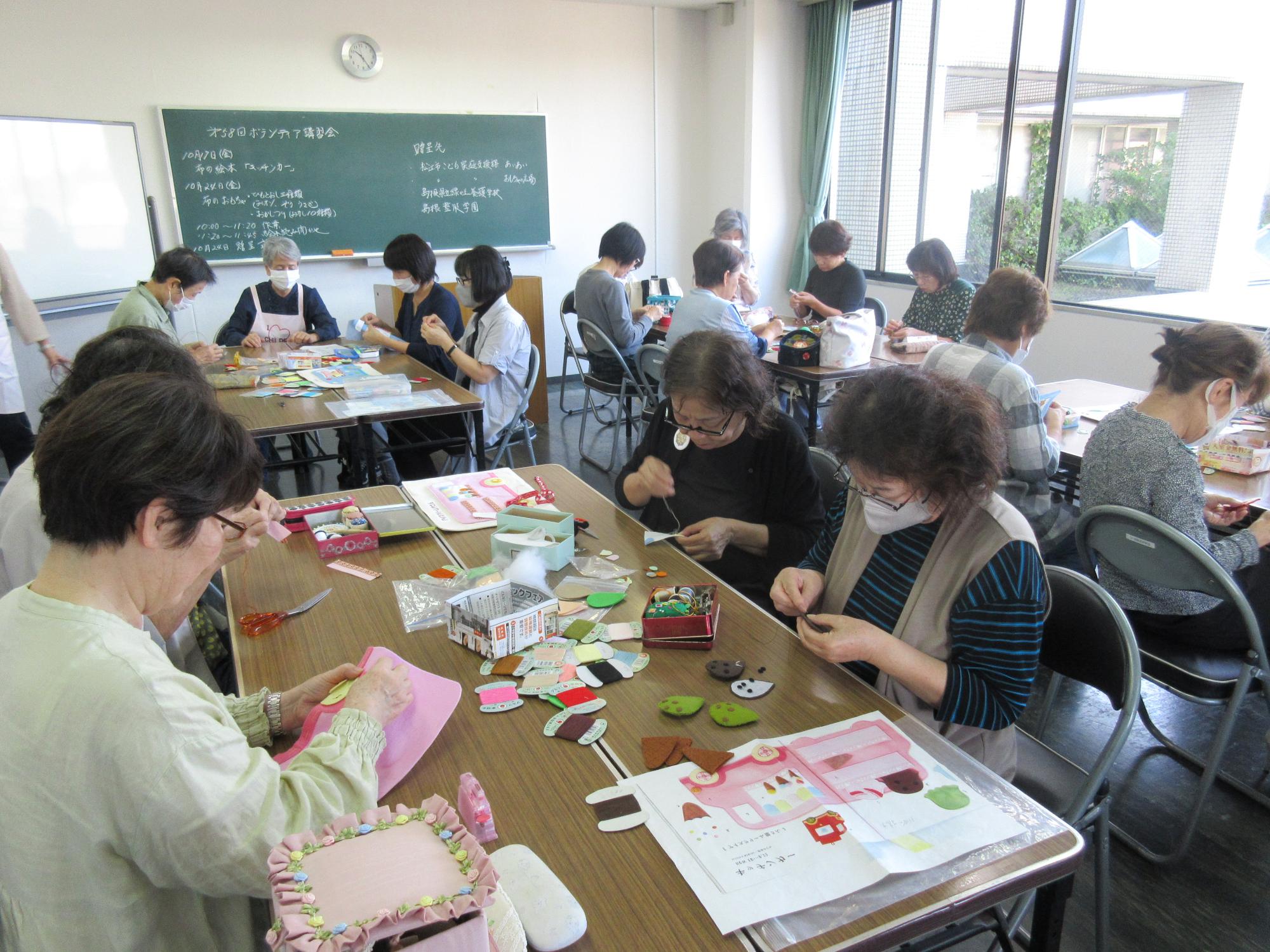 ボランティア講習会で布のおもちゃを作る参加者