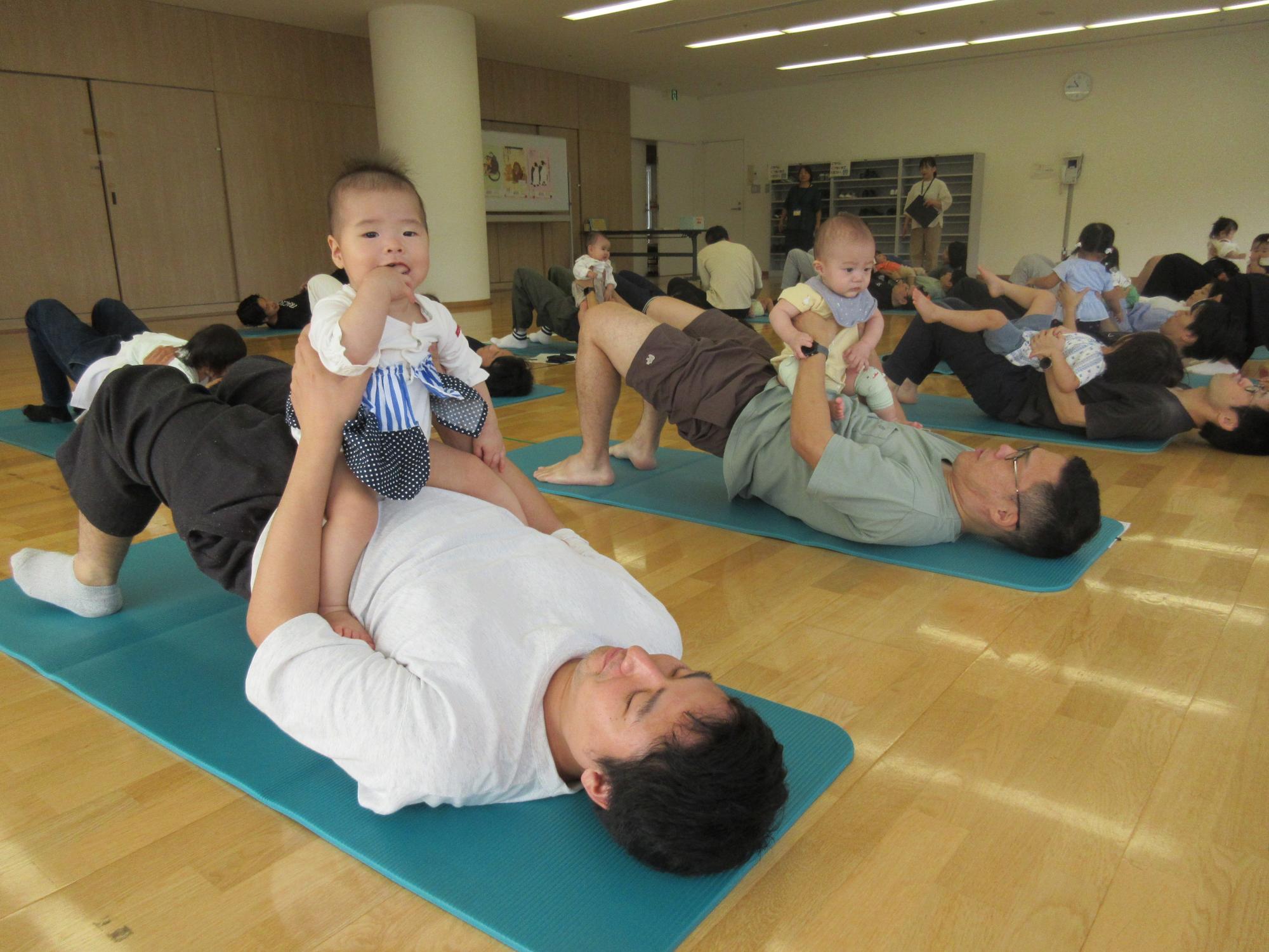 お父さんのお腹の上で笑う赤ちゃん