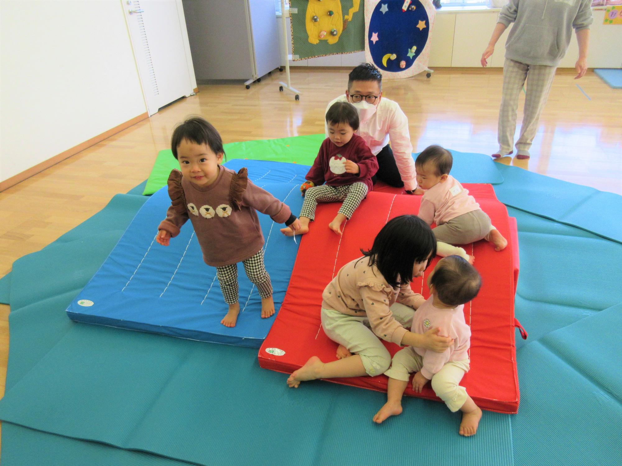 マットのお山で遊んでいるこどもたちの様子