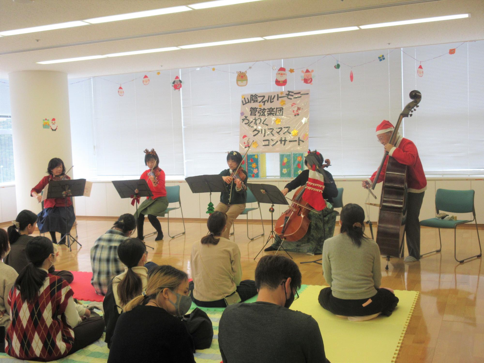 山陰フィルハーモニー管弦楽団の演奏を親子で聴いている様子