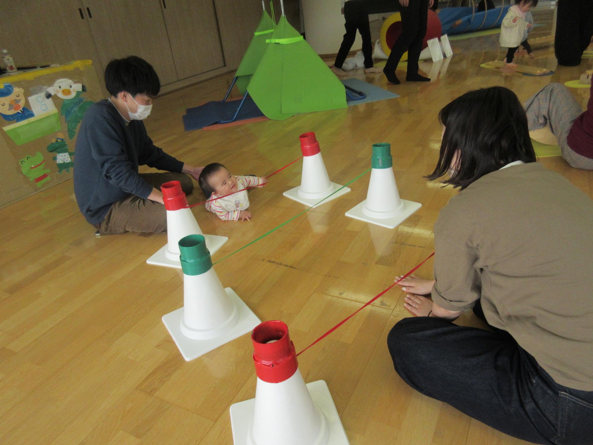 ゴムくぐりで遊ぶ赤ちゃん