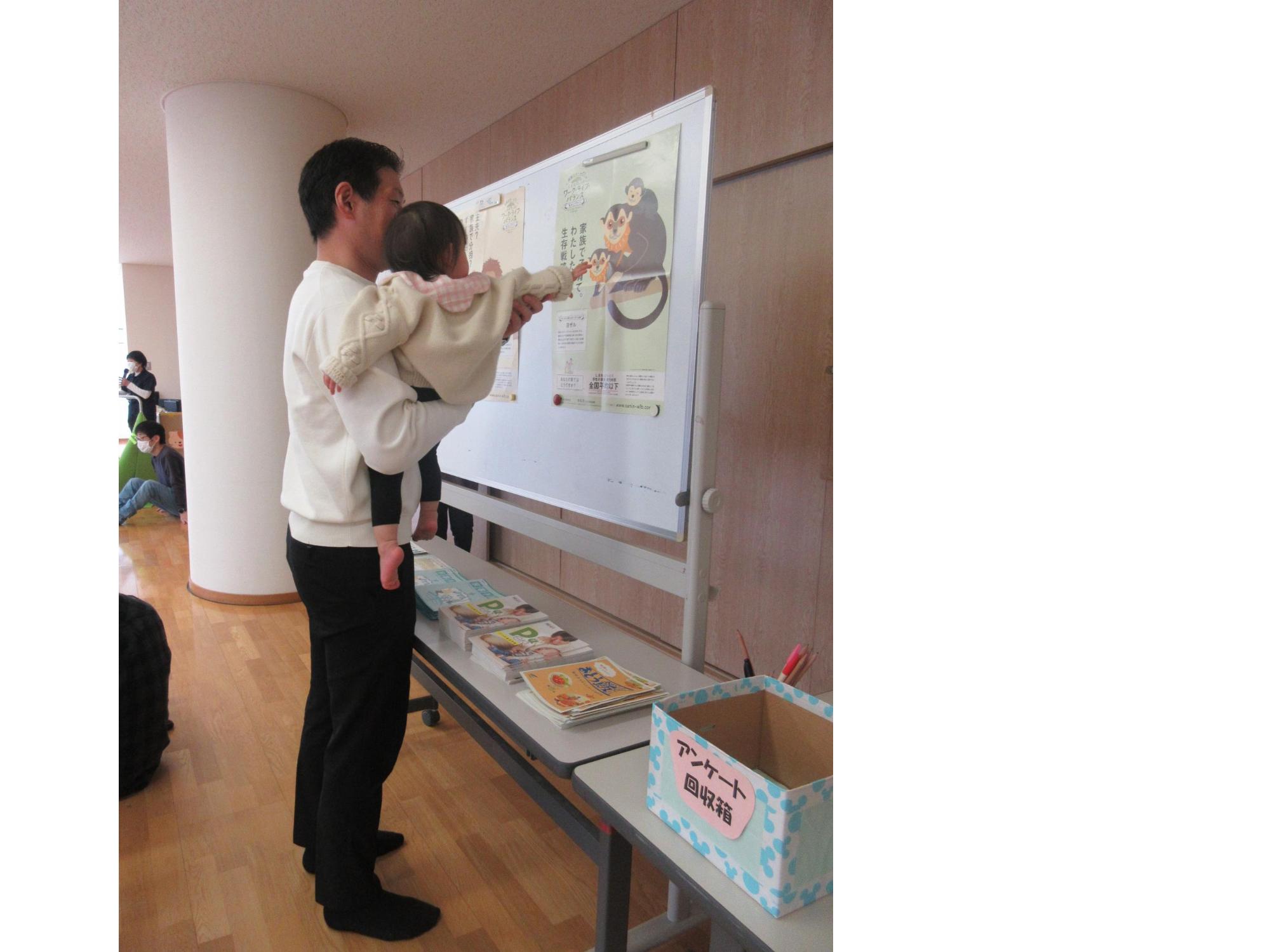 ポスターを見る親子