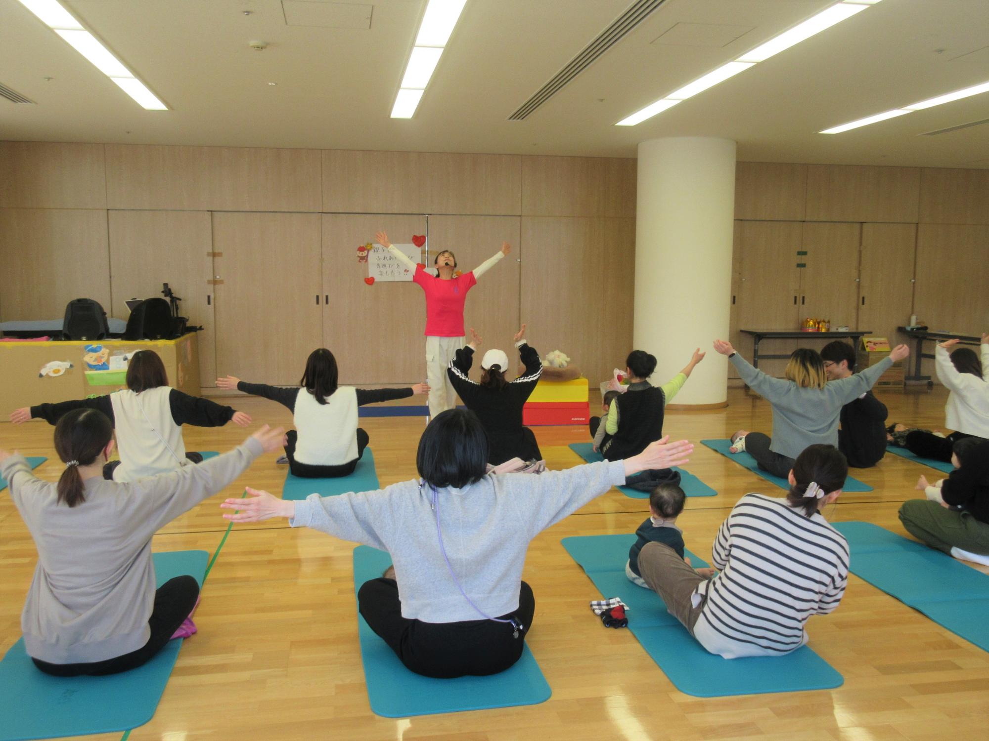 講師の先生とまずは、お母さんの体ほぐしでストレッチしている様子