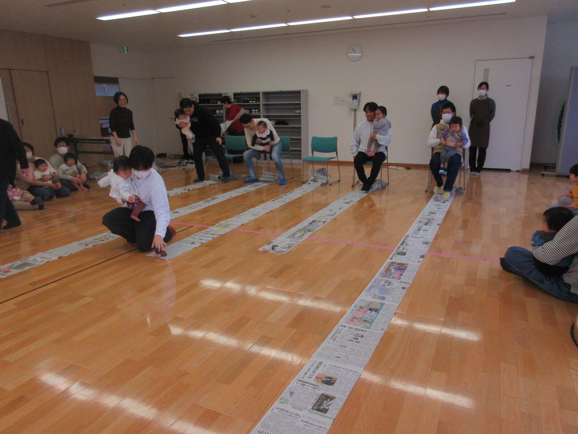 新聞紙を使った遊びをする親子