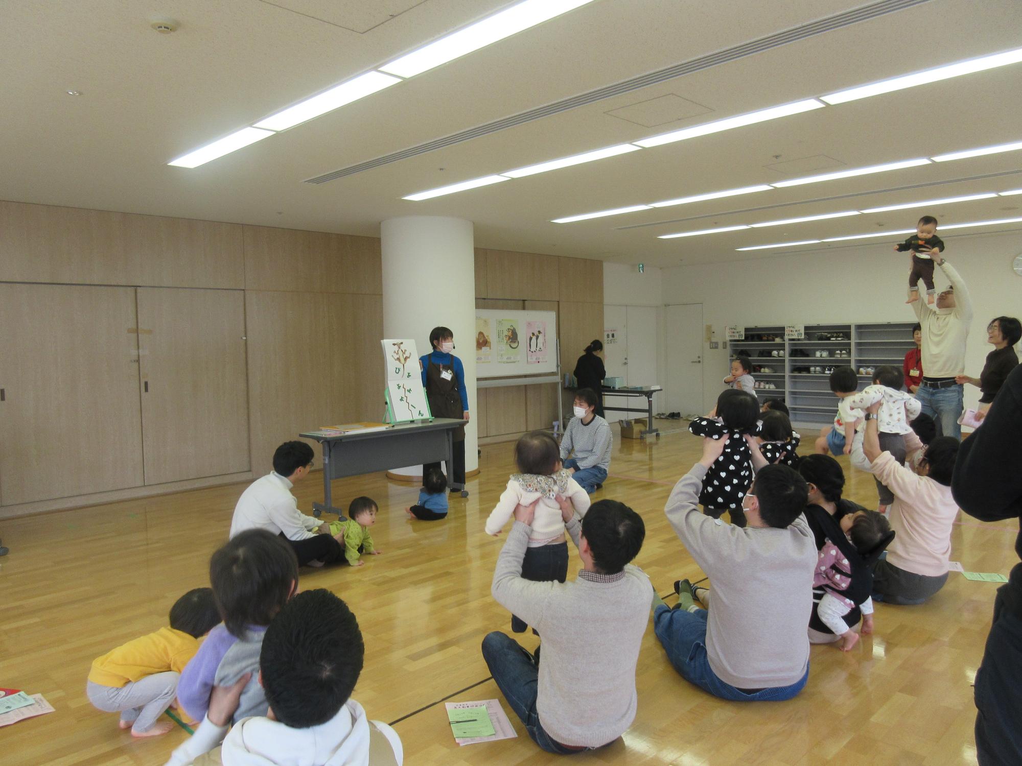 読み聞かせにあわせてふれあい遊びを楽しむ親子