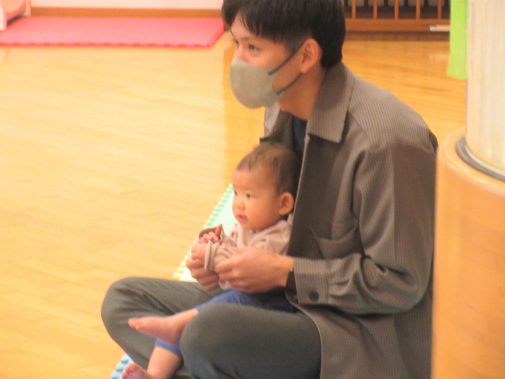 お父さんと手遊びやふれあい遊びを楽しんでいる様子